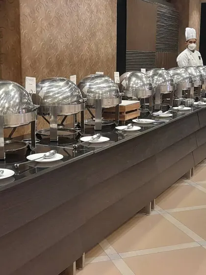A long buffet line at a hotel or banquet hall, with a chef ensuring everything is in order. This demonstrates my experience in working in professional, large scale venues.