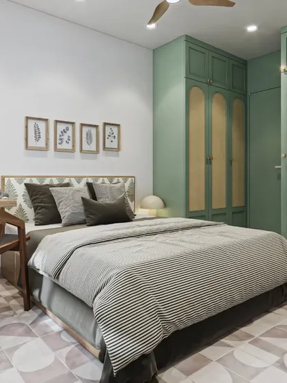 A bedroom with a modern Indian aesthetic, featuring sage green cabinets with cane webbing details and a patterned tile floor.