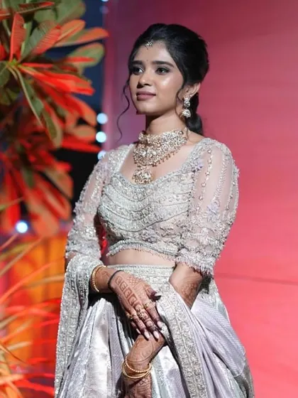 This client looks poised and elegant in her custom-designed draped saree gown. The modern design and intricate embroidery make it a perfect choice for a housewarming ceremony.