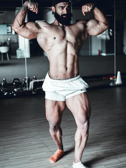 A close-up of the front double bicep, showing the muscle striations and vascularity that come from being in peak condition.