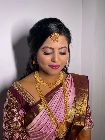 A beautiful soft glam look on a client in a traditional silk saree. The pink eyeshadow and matching lip color create a very feminine and elegant appearance.