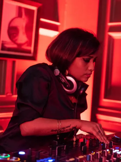 A close-up from a Women's Day event, bathed in red light. This shot shows my concentration as I mix, representing my dedication to the craft and to creating powerful moments on the dance floor.