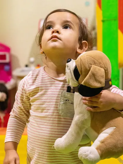 A sweet moment with a furry friend. Our soft play area is a comforting space for toddlers to explore.