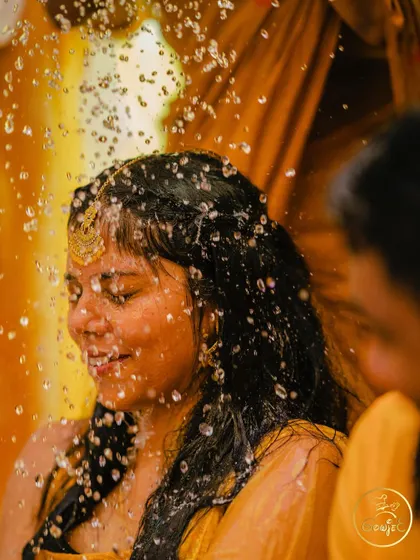 A beautiful, artistic shot of the bride as she is showered with water during her Haldi ceremony.