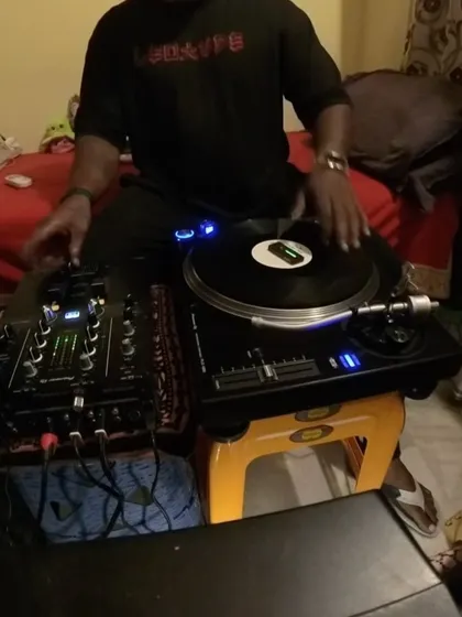 A close-up of my hands on the turntable and mixer. It's all about the feel of the vinyl.