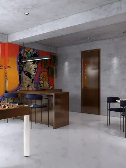 The office cafeteria, featuring a foosball table, a small bar, and dining seating. A vibrant graffiti wall adds an element of fun and creativity to this recreational space.