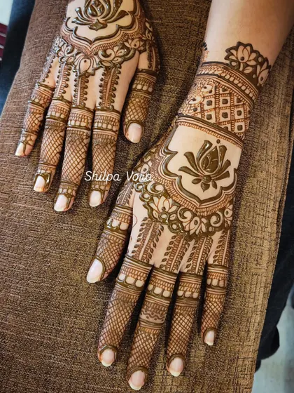 A beautiful design with a large lotus motif and a heavy net pattern on the fingers.