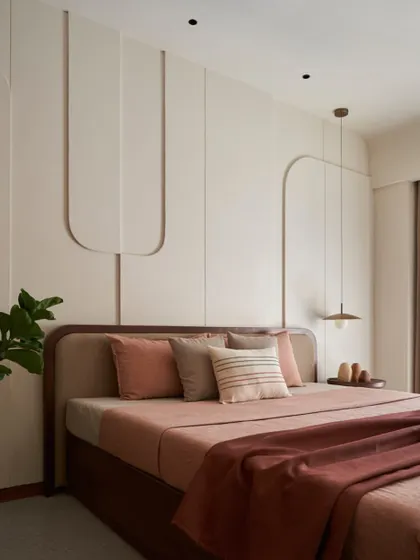 In this dusty rose bedroom, I used curved 3D cutouts on the wall to create subtle artwork. The 'less is more' philosophy is evident here, focusing on texture, soft colors, and a feeling of deep calm.