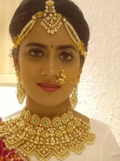 A beautiful portrait of a bride wearing the full Kundan set. You can see how the matha patti, nath, and necklace all work together to frame the face beautifully.
