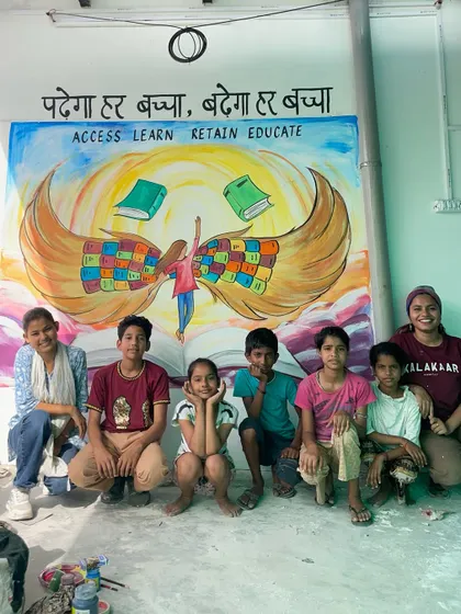 This mural, with the message 'पढ़ेगा हर बच्चा, बढ़ेगा हर बच्चा' (Every child will study, every child will progress), was created for a youth resource center in New Delhi. I worked with the children there to paint this vision of education giving them wings to fly. Posing with them in front of the finished piece was a moment full of hope.