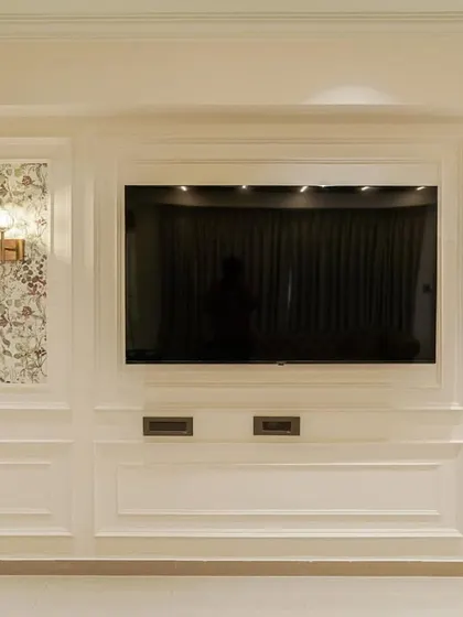 A detailed shot of the elegant TV wall unit from image 61, featuring classic moulding and floral wallpaper panels.