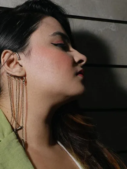 A detailed side-profile shot specifically capturing a modern, multi-chain ear cuff, ideal for showcasing unique and trendy accessory designs.