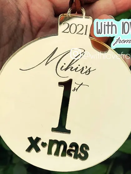This round acrylic ornament is a modern and stylish way to celebrate a baby's "1st X-mas". The clean design and personalized name make it a beautiful addition to any Christmas tree.