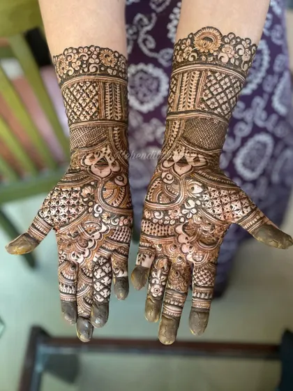 Full coverage mehendi with detailed wristbands and intricate patterns filling the palms. This is a classic choice for any celebration.