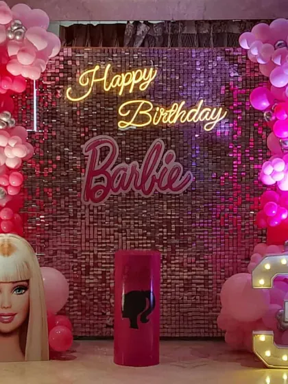 It's a Barbie world! This glamorous Barbie-themed birthday features a pink sequin wall, a neon "Happy Birthday Barbie" sign, and a life-sized Barbie head cutout for the perfect photo opportunity.