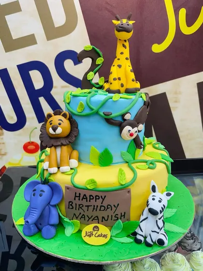 A large 6kg two-tiered jungle cake with a full scene of fondant animals, perfect for a big celebration.