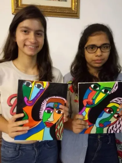 Teamwork makes the dream work. These two students proudly present their matching Picasso-inspired paintings, each with its own unique flair, created during a fun and collaborative art session.