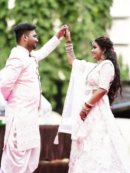 A candid moment between the couple. The bride's makeup looks fresh and beautiful, even in natural outdoor lighting.