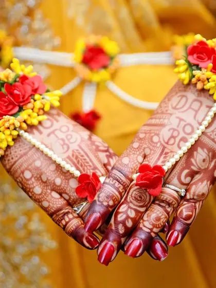 A close-up of the beautiful floral jewelry and intricate mehndi worn by the mom-to-be, highlighting the traditional details of her baby shower attire.