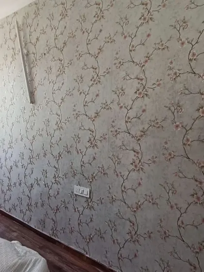 A grey wallpaper with a pink cherry blossom trail pattern.