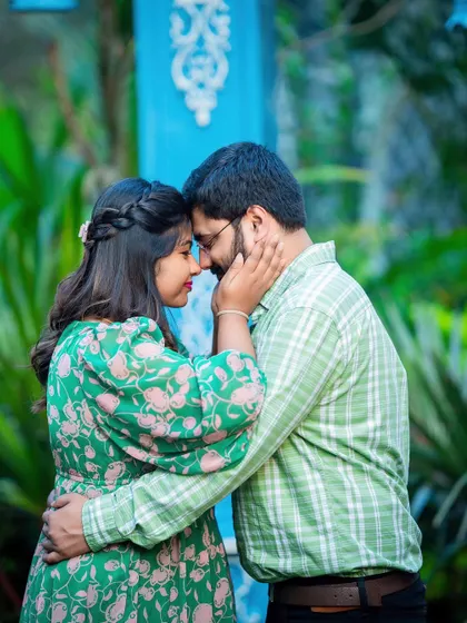 An intimate and tender moment between a couple, surrounded by the vibrant green of a garden.