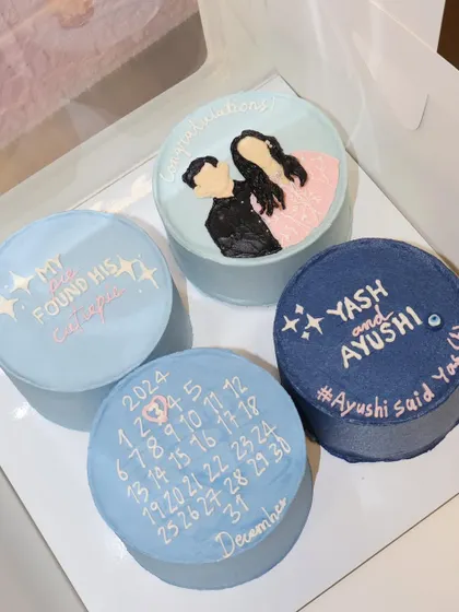 A beautiful set of four bento cakes to celebrate an engagement. We created a custom calendar marking the special date, a portrait of the couple, their names, and a cute message to announce the big news.