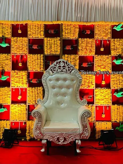 For a truly traditional seemantham or baby shower, we designed this vibrant backdrop. It features a grid of fresh marigold flowers, accented with paper parrots and hanging bangles, creating a festive and colorful setting for the mom-to-be.