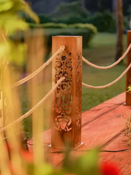 A detail of the wooden stanchions with rope barriers that lined the entrance walkway. The posts feature carved floral motifs, adding a touch of elegance to the rustic design.