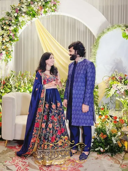 The happy couple, Tanya and Shavak, posing against the beautiful pastel floral backdrop of their Roka ceremony.