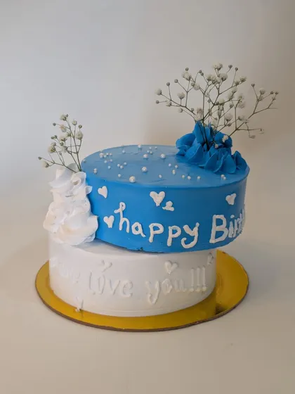 A lovely two-tier blue and white cake. The handwritten messages and delicate baby's breath flowers add a personal and romantic touch.