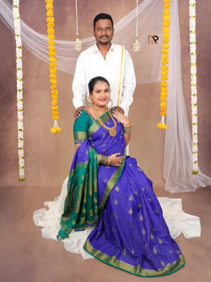 A beautiful portrait of the couple against a backdrop decorated with marigold garlands, adding a festive and traditional Indian touch to the session.