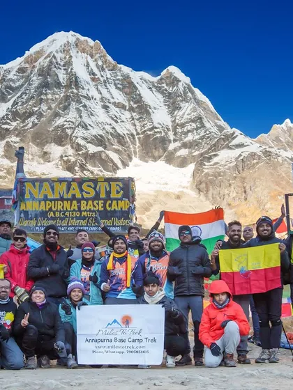 We made it. A team celebrates their incredible achievement at the Annapurna Base Camp, with the majestic peak in the background. This is a true adventure of a lifetime.