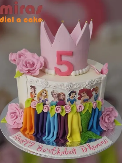 A cake fit for a little princess, featuring an entire lineup of beloved Disney princesses along the side. Topped with a pink crown and roses, this cake is a fairy tale dream for a fifth birthday.