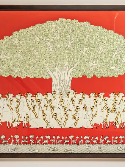 A close-up of the 'Tree of Life' artwork. This custom piece, with its intricate details and vibrant red background, serves as the heart of the dining space, symbolizing growth and harmony.