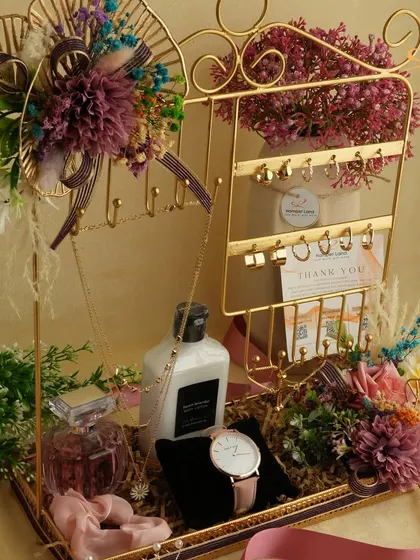A gift designed for someone who loves to accessorize. This hamper features a jewelry stand, perfume, lotion, a watch, and other personal items, all elegantly arranged in a decorative tray.