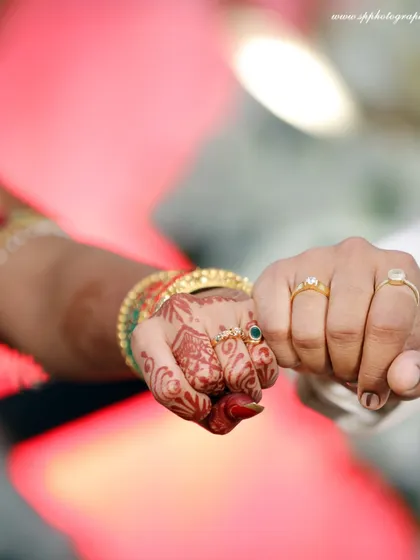 A creative shot of the couple's hands, showcasing their wedding rings. This simple gesture of a fist bump adds a modern and personal touch.