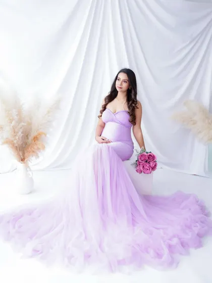 A dreamy portrait in a beautiful lavender gown. The soft tulle and floral props create a romantic and whimsical atmosphere.