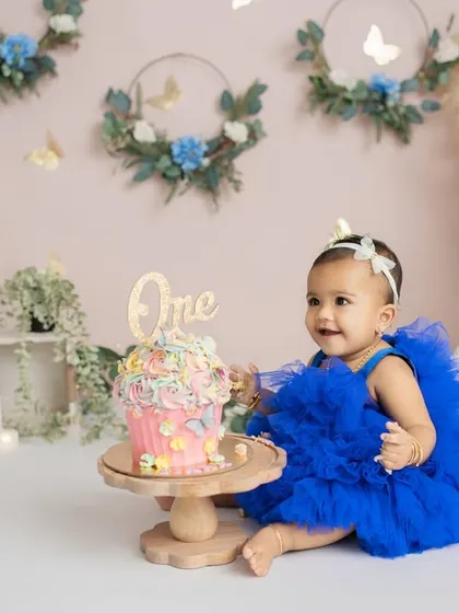 A gentle touch and a sweet smile before the smashing begins. These are the quiet, anticipatory moments of a first birthday shoot.