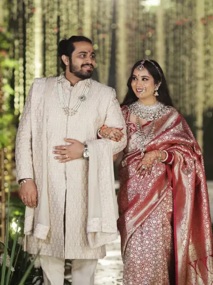 A beautifully dressed couple walks together during their reception, their coordinated outfits reflecting the elegance of the event.