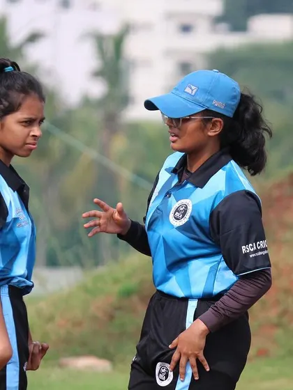 Two female players strategize on the field during their Dasara Cup match.
