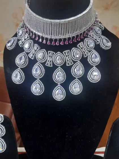 A glamorous American Diamond necklace set with large teardrop stones and a ruby-accented choker.