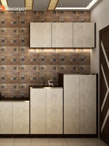 A practical and stylish shoe storage unit for an entryway. The design features cabinets in varying heights against a textured tile wall, with under-cabinet lighting for a warm glow.