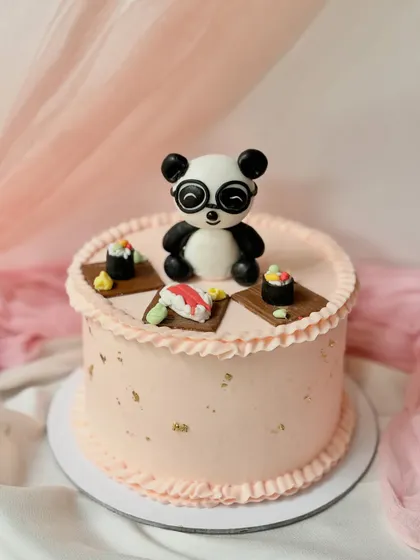 A quirky and fun cake featuring a panda wearing glasses and enjoying some sushi. This design is perfect for someone with a unique sense of humour.