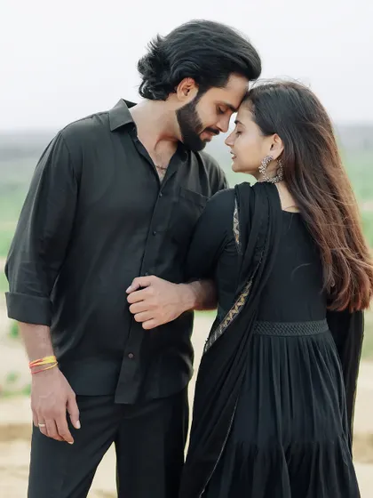 An intimate portrait in the sand dunes, with the couple in matching black outfits creating a classic and timeless look.