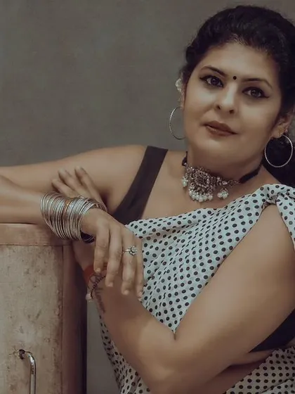 A confident pose in a polka dot saree, captured in timeless black and white.