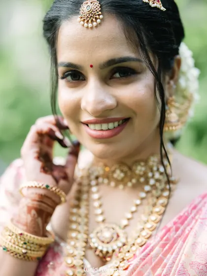 A beautiful, smiling close-up of the bride, showcasing her natural beauty and intricate jewelry.