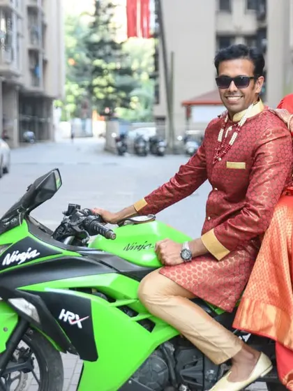 A fun and modern post-wedding shot! The newly married couple poses with a superbike, adding a cool and edgy vibe to their wedding photos.