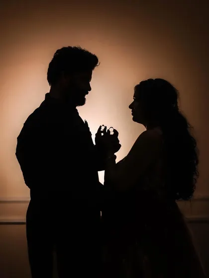 A silhouette of the couple dancing, with their engagement rings subtly highlighted.