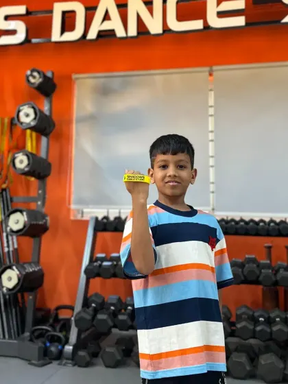 Achyuth proudly displays the yellow band he earned for his top performance in the basic level. Congratulations.