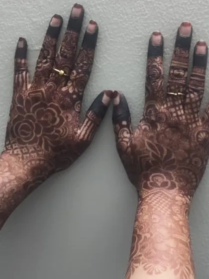 A close-up of the stain on the back of the hands. The floral patterns have developed into a beautiful deep brown, showing the quality of the organic henna.